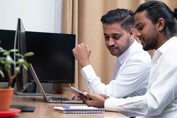 A man working on laptop and pointing to screen